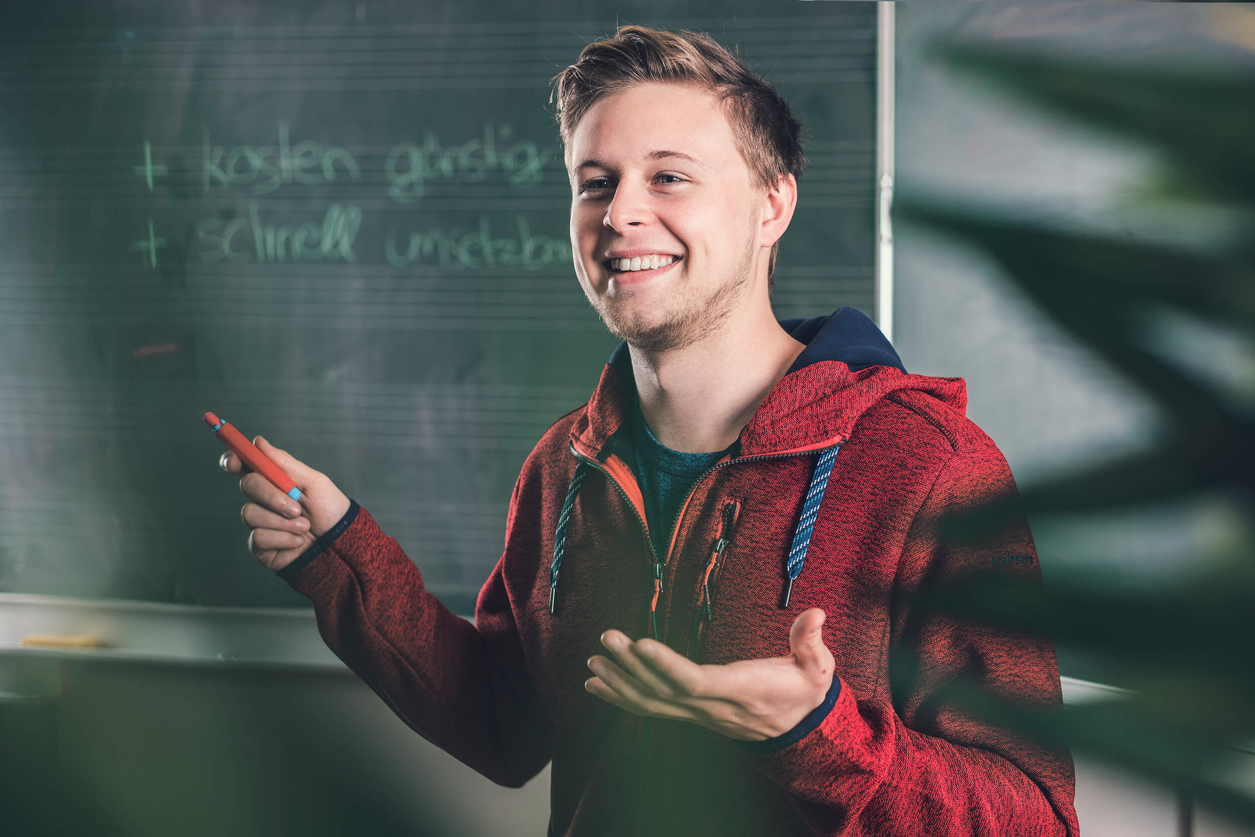 Sebastian erklärt an der Tafel die Vor- und Nachteile der unterschiedlichen Marketing Kanäle