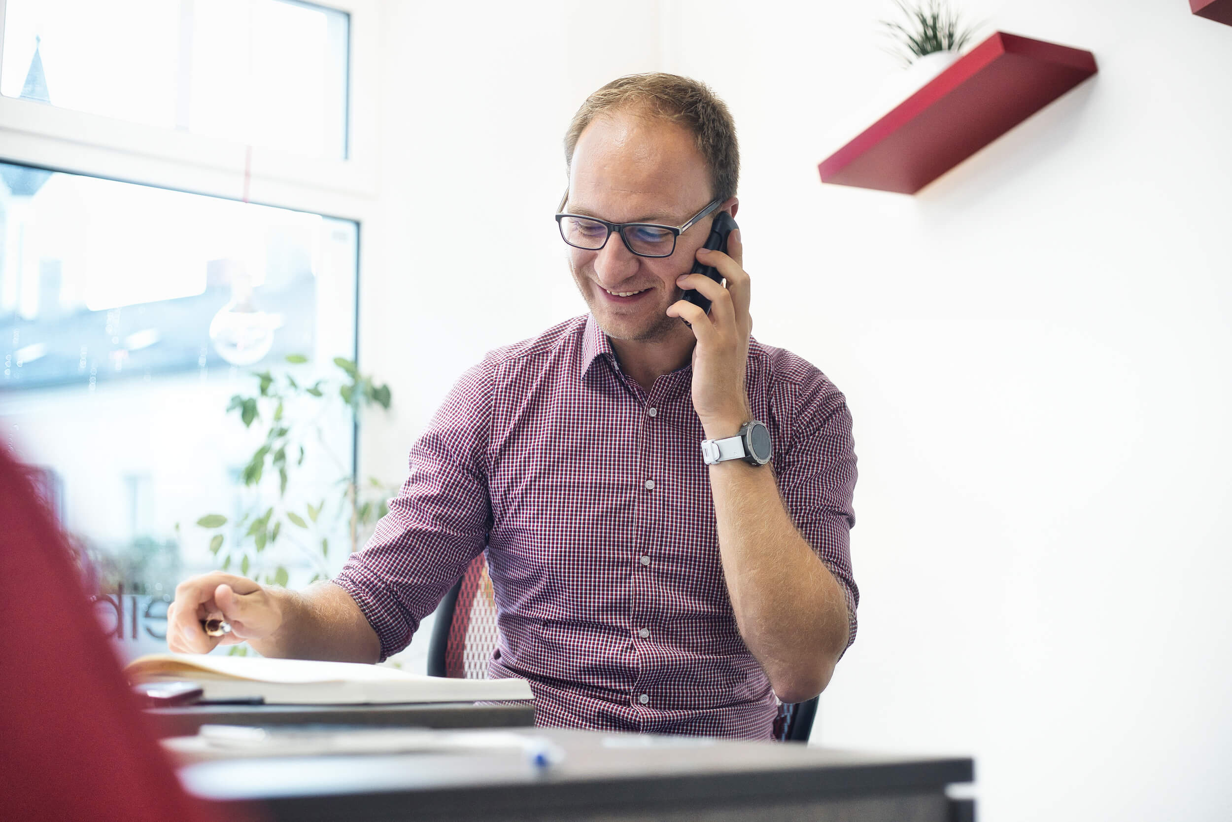 Florian Werner telefoniert mit einem Kunden und spricht über das Konzept der Homepage