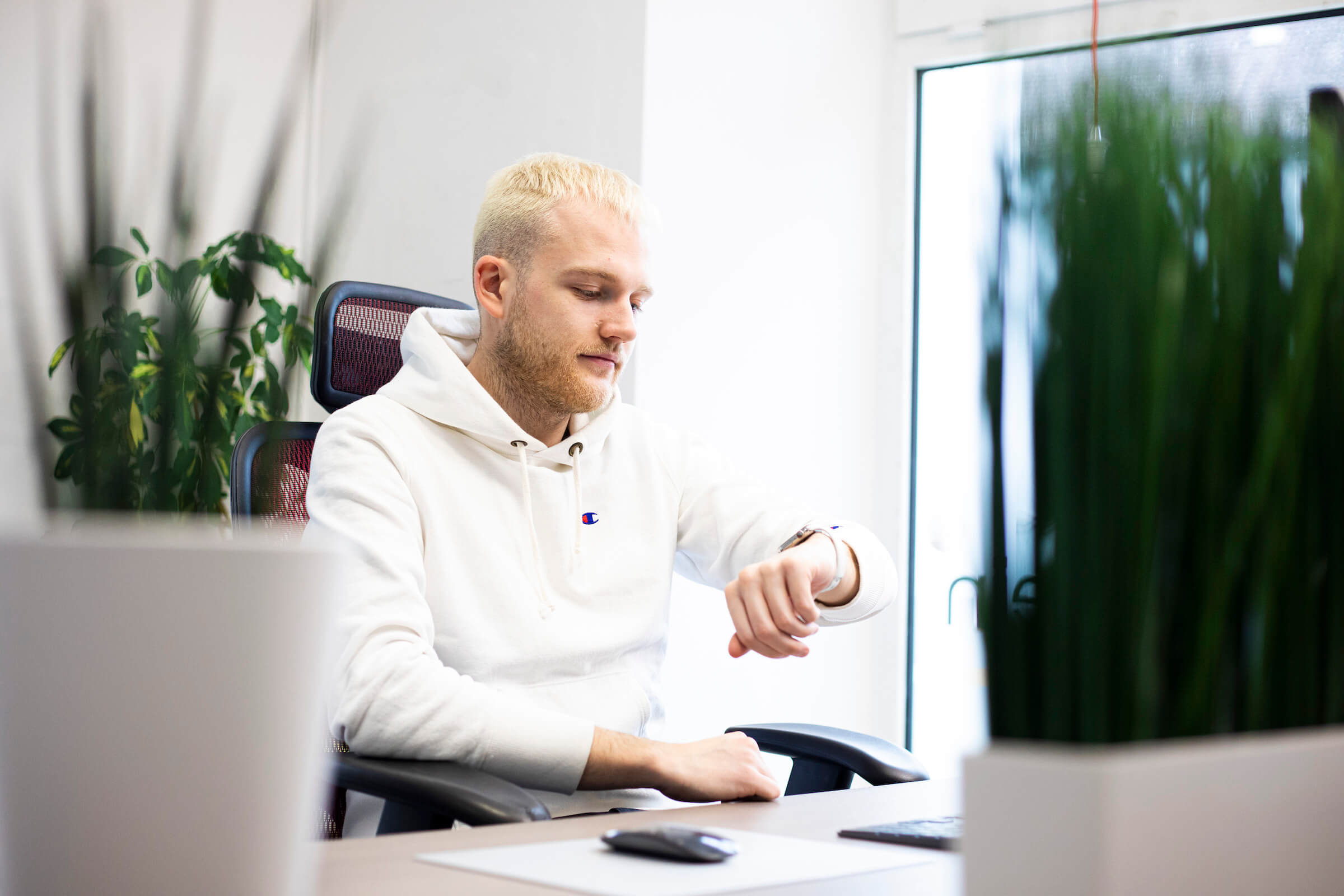 Mitarbeiter der Werbeagentur dreibein sieht auf die Uhr